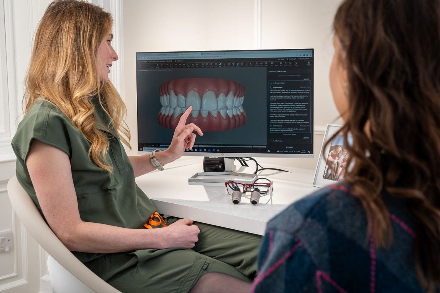 Dentist taking a patient through a full arch scan on screen before rehabilitation