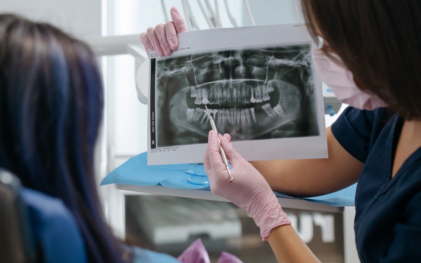 Dentist showing a patient their dental x-ray during a consultation
